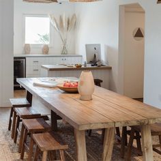 a wooden table sitting in the middle of a kitchen