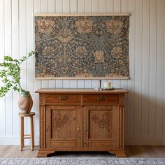 a painting hanging on the wall next to a wooden cabinet