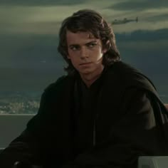 a young man with long hair wearing a star wars outfit and looking at the camera