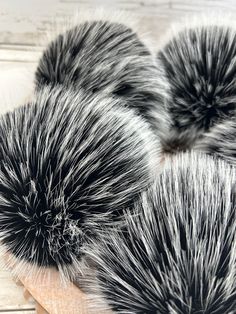 three black and white brushes sitting on top of a wooden table