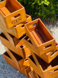 a stack of wooden crates sitting on top of a cement floor next to green plants