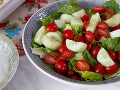 a salad with cucumbers, tomatoes and lettuce in a bowl