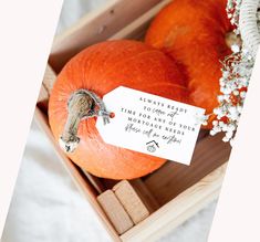 two pumpkins in a wooden box with a note attached to the front and side