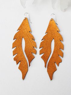 two pairs of wooden earrings with leaves on them