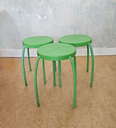 three green tables sitting on top of a carpeted floor