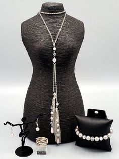 This sophisticated white and silver custom set comes with a necklace and complimentary earrings, a stretchy bracelet and and a ring with a stretchy back.Necklace - "Timeless Tassels": Dainty silver pearls and sparkling white crystal-like beads gives way to two shimmery silver chain tassels. Infused with ornate silver beads, strands of matching beads trickle down the tassels for a refined flair. Features an adjustable clasp closure. Includes one pair of matching earrings. Bracelet - "Really Respl Silver Metal Pearl Necklace For Party, Silver Pearl Chain Jewelry For Party, Party Silver Jewelry With Pearl Chain, Silver Pearl Jewelry For Party, Silver Pearl Jewelry Sets With Pearl Chain, Adjustable Silver Beads Jewelry For Party, Silver Pearl Jewelry With Silver Beads, Silver Crystal Jewelry With Pearl Drop, Pearl Jewelry With Bling For Gift