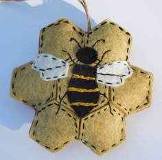 a felt bee ornament hanging from a string