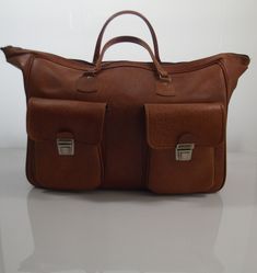 Vintage brown imitation leather sportsbag / weekend bag from the 70s In good condition 2 front pockets Sizes H xW x D ± 35 x 51 x 21 cm Brown Briefcase With Luggage Sleeve For Trips, Brown Duffle Bag With Pockets, Brown Travel Bag For Trips, Brown Travel Bag For Trip, Everyday Brown Duffle Bag With Pockets, Brown Shoulder Bag With Luggage Sleeve For Trip, Vintage Satchel Weekender Bag For Travel, Brown Travel Bag With Luggage Sleeve For Trip, Brown Weekender Bag With Luggage Sleeve For Trips