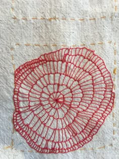 a piece of red thread on white fabric