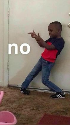 a little boy leaning against a wall with the word no in front of him and pointing at it