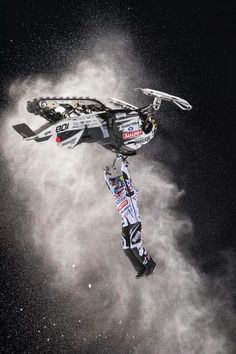 a man flying through the air while riding skis on top of snow covered ground