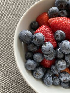 blueberries and strawberries in a white bowl