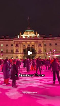 people are walking around in front of a building with pink lights on it and the words state 6 somerset house