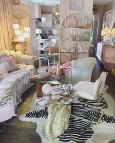 a living room filled with furniture and lots of pink decor on top of a wooden floor