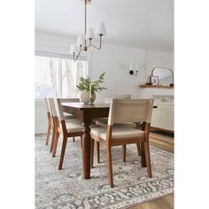 a dining room table with chairs and a rug