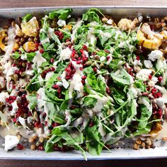 a salad with spinach, feta cheese and pomegranate on top