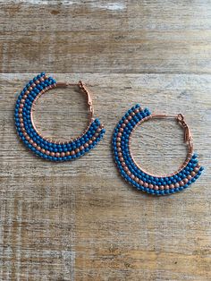 Large copper tone hoops with added glass beads. They are a blue color with a strip of tan/beige beads. They measure 2 inches long.  Hand beaded by me! Blue Beaded Round Hoop Earrings, Blue Beaded Small Hoop Jewelry, Handmade Blue Round Hoop Earrings, Blue Beaded Small Hoop Earrings, Small Blue Beaded Hoop Earrings, Handmade Blue Beaded Hoop Earrings, Blue Hoop Earrings With Ear Wire, Adjustable Small Hoop Earrings In Blue, Adjustable Small Blue Hoop Earrings