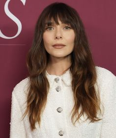 a woman with long hair wearing a white jacket