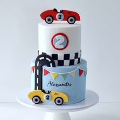 a three tiered cake with cars on top and the number two on the side