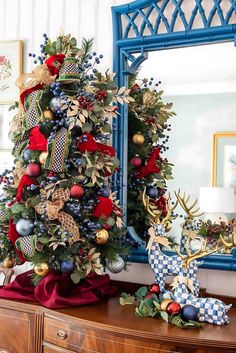 a decorated christmas tree in front of a mirror