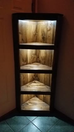 an empty shelf in the corner of a room with tile flooring and wooden walls