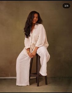 a woman sitting on top of a wooden stool