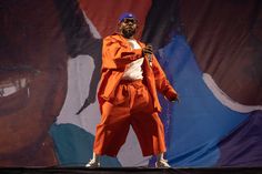 a man in an orange outfit on stage