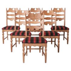 a set of six wooden chairs with red and black striped upholstered seat cushions