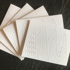 five white cards with trees on them sitting next to each other in front of a black background