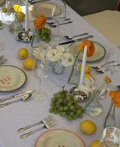 the table is set with plates, silverware, and lemons for an elegant dinner