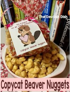 a bowl filled with lots of nuts next to a pile of books and a sign that says copycat beaver nuggets