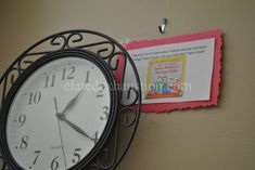 a clock is hanging on the wall next to a sign that says it's 11 o'clock