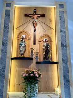 the crucifix is displayed in front of a wall with flowers on it