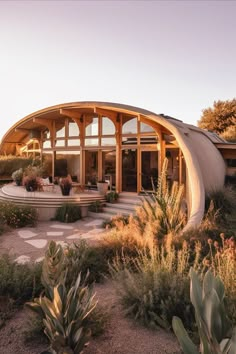 an earthship home surrounded by cactus and succulents with text overlay reading 50 + gorgeous futuristic earthship homes