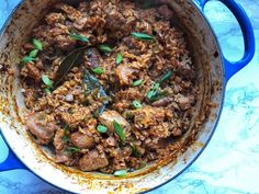 a blue pot filled with meat and vegetables