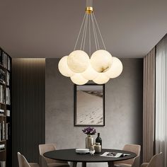 a dining room table with four chairs and a chandelier hanging from the ceiling