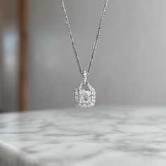 One (1) 14KT white gold cushion cut diamond halo pendant 88/100ctw. Prong set in the center with one cushion cut diamond 72/100CT of (G) color (I1) clarity GIA Certified. Diamond halo and bail is prong set around center with (38) round brilliant cut diamonds 16/100CTW of fine (G-H) color and (SI) clarity. Luxury Jewelry With Cushion Cut Diamond Accents, Luxury Cushion Cut Jewelry With Diamond Accents, Square Cut Moissanite Jewelry With Halo Setting, Moissanite Diamond Necklace In White Gold With Halo Setting, Timeless Lab Grown Diamond Halo Jewelry, Silver Jewelry With Lab Grown Diamond And Halo, Dazzling Square Cut Moissanite Jewelry, Radiant Cut Halo Jewelry For Anniversary, Silver Radiant Cut Lab Grown Diamond Jewelry