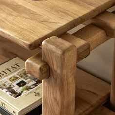 a wooden table with two books and a bowl of fruit on the top, sitting next to it