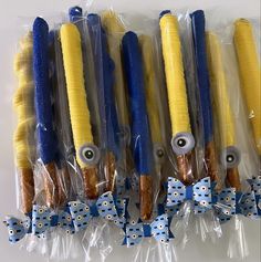 five plastic wrapped candy sticks with blue and yellow decorations