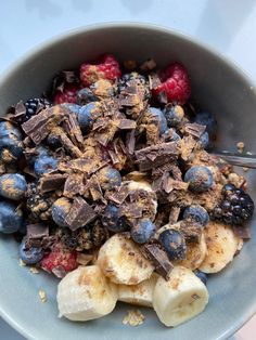 a bowl filled with chocolate and fruit on top of a table