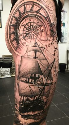 a man's thigh with a ship and compass tattoo on it