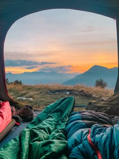 two people are sleeping in their tents at sunset