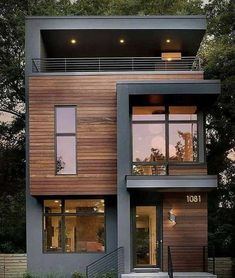 a two story house with lots of windows and balconies on the top floor