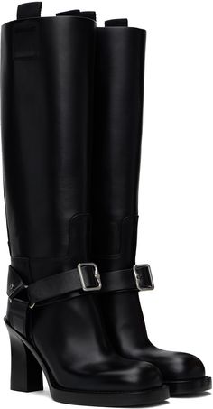 Knee-high buffed calfskin boots in black. · Pin-buckle ankle strap · Webbing pull-loops at collar · D-ring at sides · Topstitching at welt · Stacked calfskin heel with rubber injection · Logo embossed at calfskin sole · Heel: H3.75 Supplier color: Black Black Pins, Burberry Black, Stirrups, Boots Knee, D Ring, Knee High Boots, High Boots, Knee High, Calf Skin