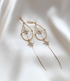 Our long elegant bridal earrings are the perfect addition to any wedding ensemble. Made with high-quality gold plated components and sparkling cubic zirconia, they add a touch of minimalistic, yet statement-worthy glamour. Elevate your look and make a subtle yet stunning statement with these earrings. - Handcrafted in my PA studio - Earrings measure 4.25 inches - Available in rose gold, yellow gold and rhodium (silver) - Handcrafted in the US. - Nickel free and hypoallergenic - PLEASE ALLOW APPR Gold Diamond Chandelier Earrings With Elegant Design, Delicate Bridal Drop Earrings With Elegant Design, Elegant Hoop Earrings With Diamond Accents For Wedding, White Gold Dangle Hoop Earrings For Wedding, Elegant Cubic Zirconia Hoop Earrings For Wedding, Elegant Diamond Accents Hoop Earrings For Wedding, Gold Cubic Zirconia Chandelier Earrings With Elegant Design, Gold Cubic Zirconia Chandelier Earrings For Celebration, Wedding Dangle Diamond Hoop Earrings