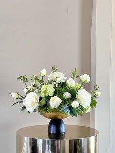 a vase filled with white flowers sitting on top of a table