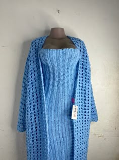 a blue knitted sweater hanging on a wall