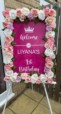 a welcome sign with pink and white flowers