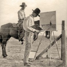 a man standing next to a horse near a easel with a painting on it