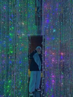 a man standing in front of a wall covered with lights